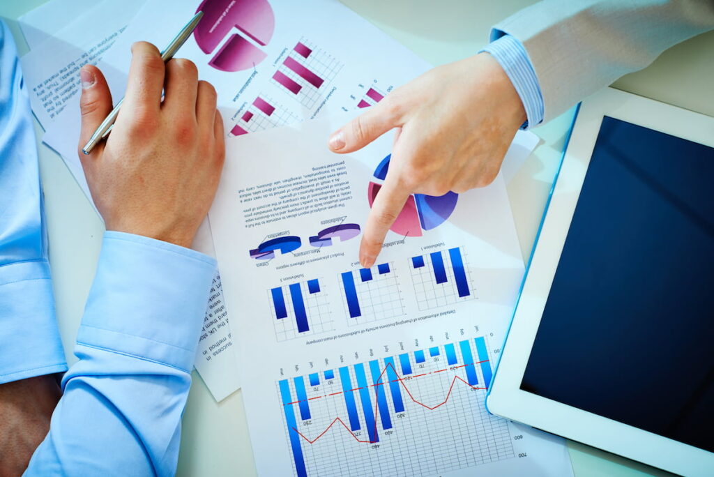 Two people reviewing charts and graphs displaying data about the Canadian industrial real estate market.