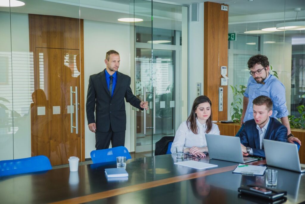 Four canadian real estate professionals, including one woman, and three men, collaborating in a modern boardroom.
